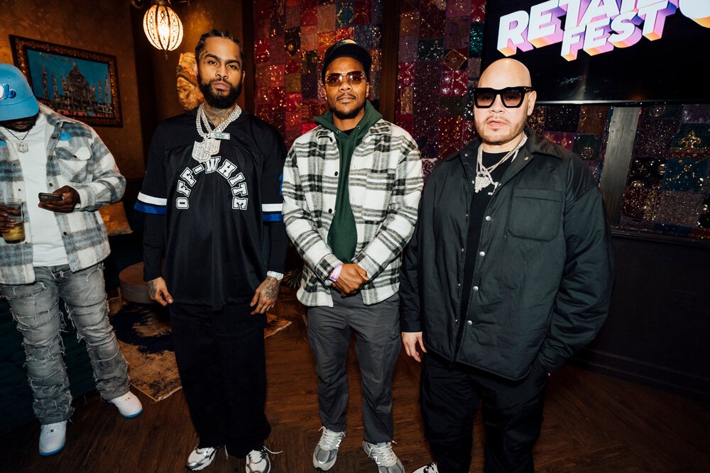 Three stylish men posing for a photo at Retail Fest, with one of them being Fat Joe, standing against a colorful backdrop, organised by emc3, a global events agency