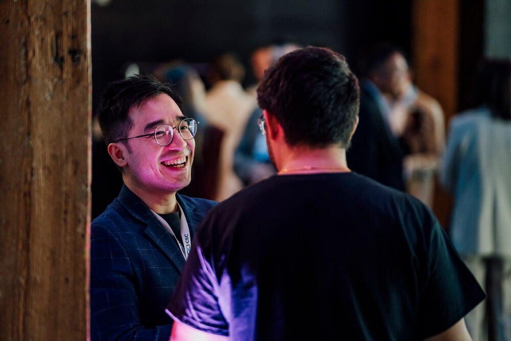 A candid moment of guests interacting at the TikTok Shop event. Smiles and laughter indicate a friendly and engaging environment.