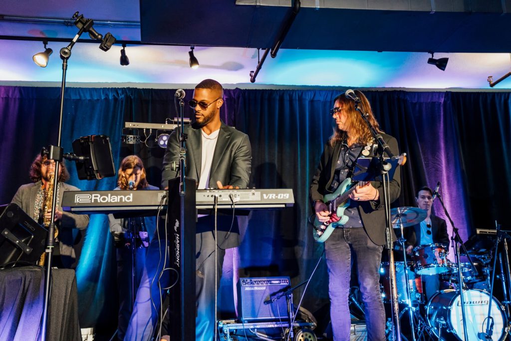 A live band performing on stage at the TikTok Shop event. The vibrant lighting and energetic music add to the lively atmosphere.