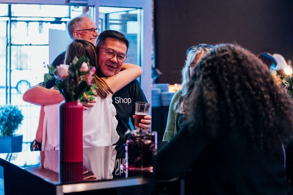 Warm greetings and embraces among attendees at the TikTok Shop event, showcasing the camaraderie and positive connections made.