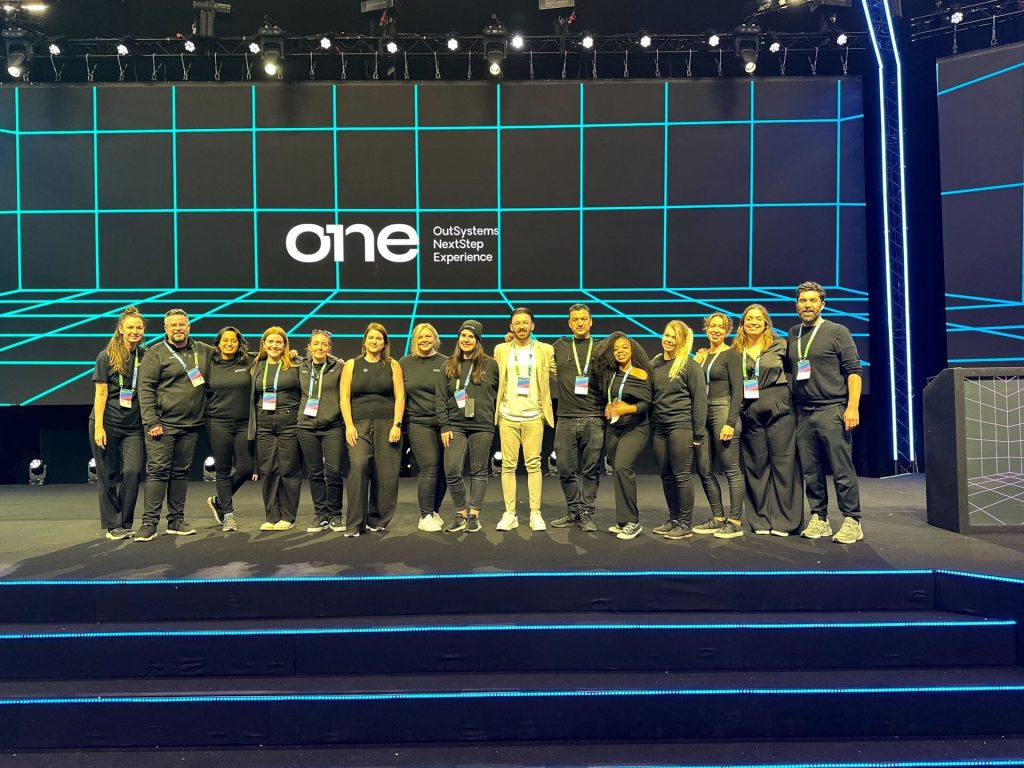 emc3 Team photo on stage with OutSystems branding